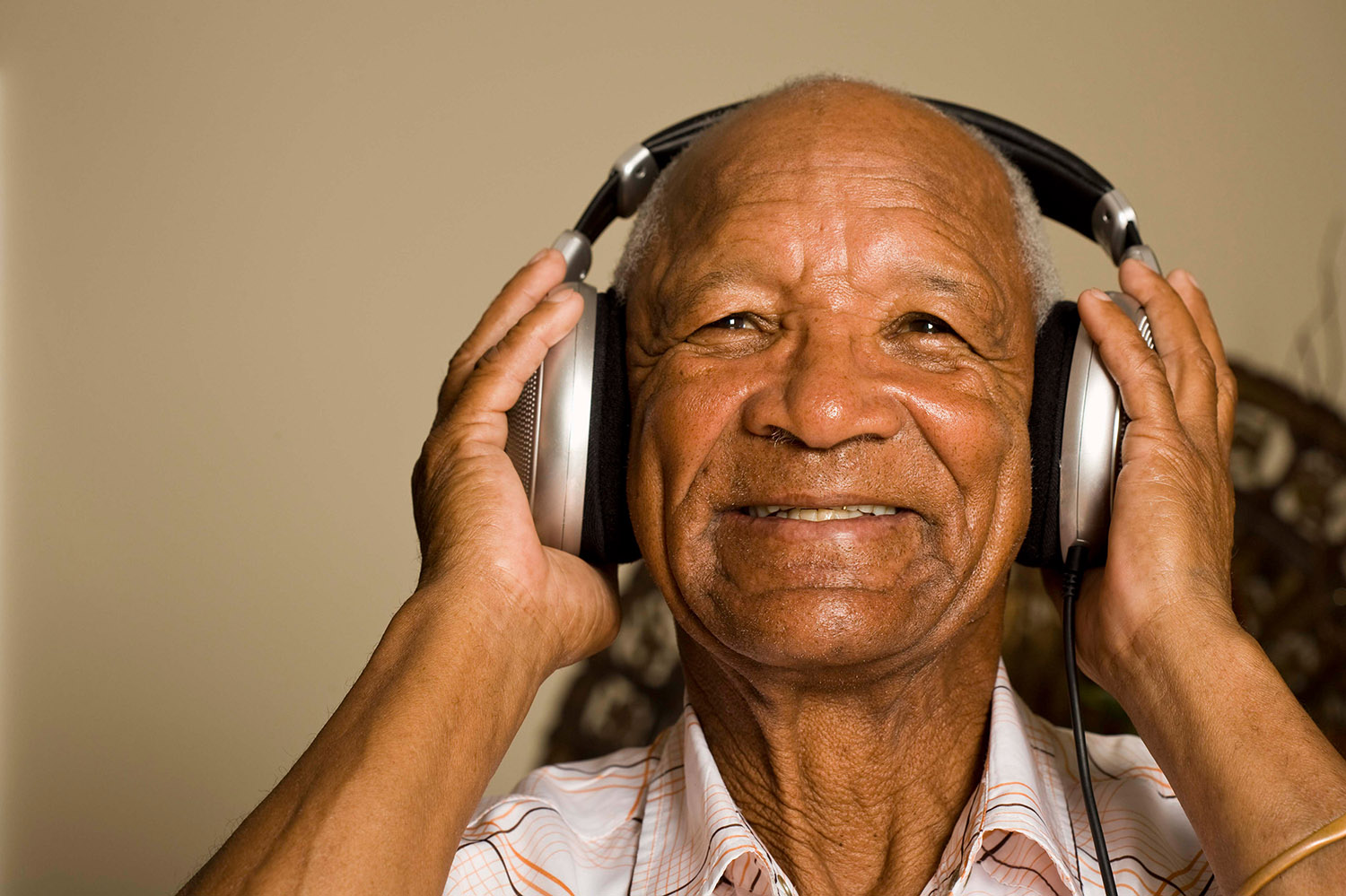 Black man smiling listening to music.